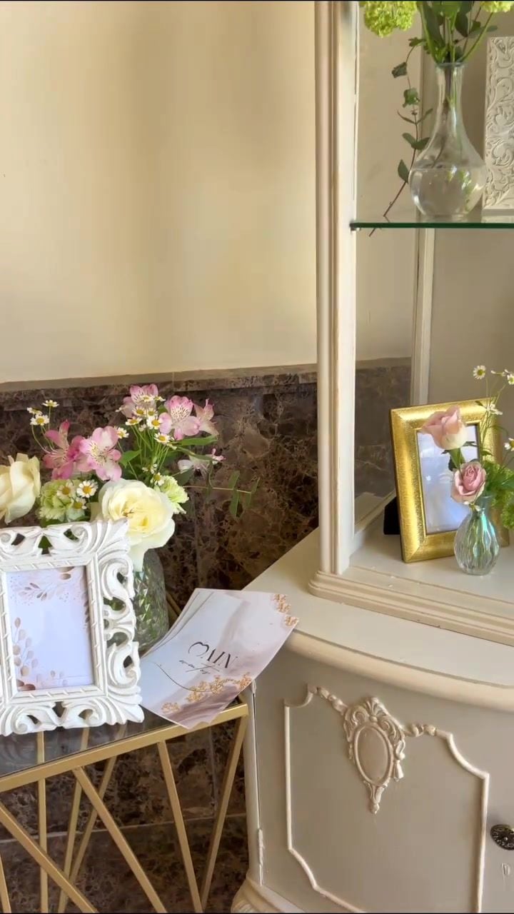 Aparador clásico con flores blancas y marcos dorados