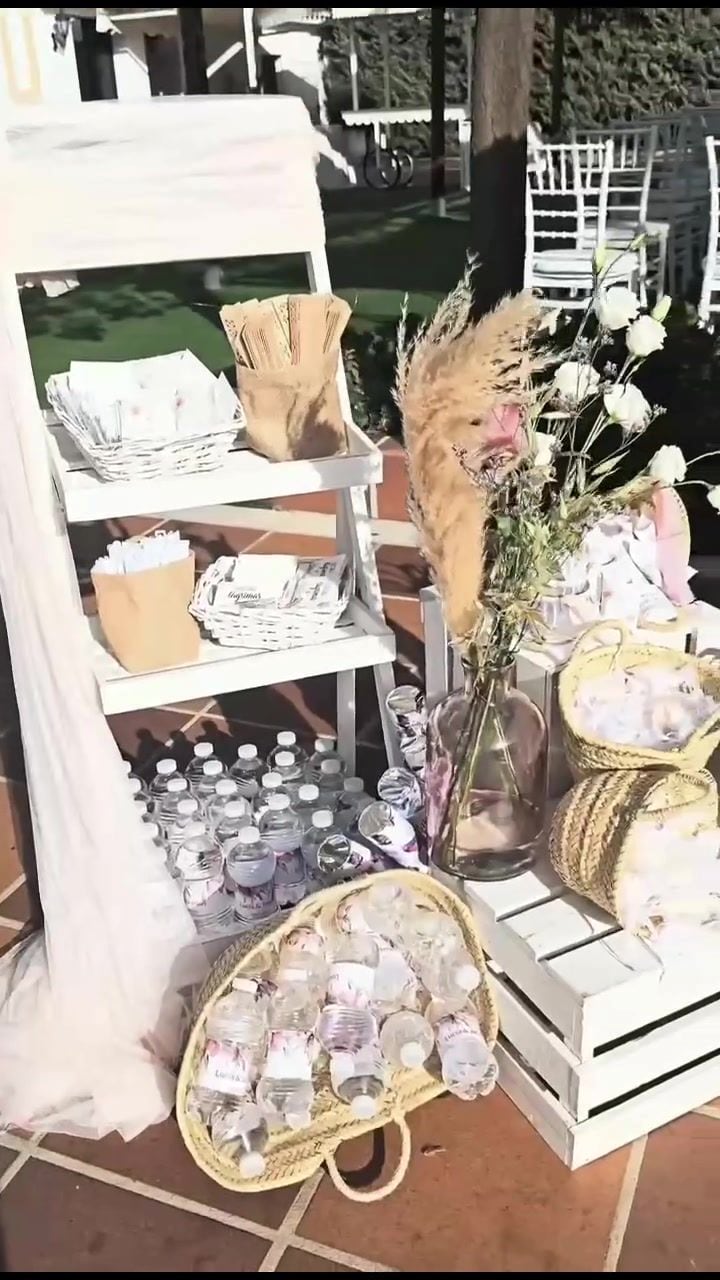 Estantería blanca con botellas de agua y detalles para los invitados